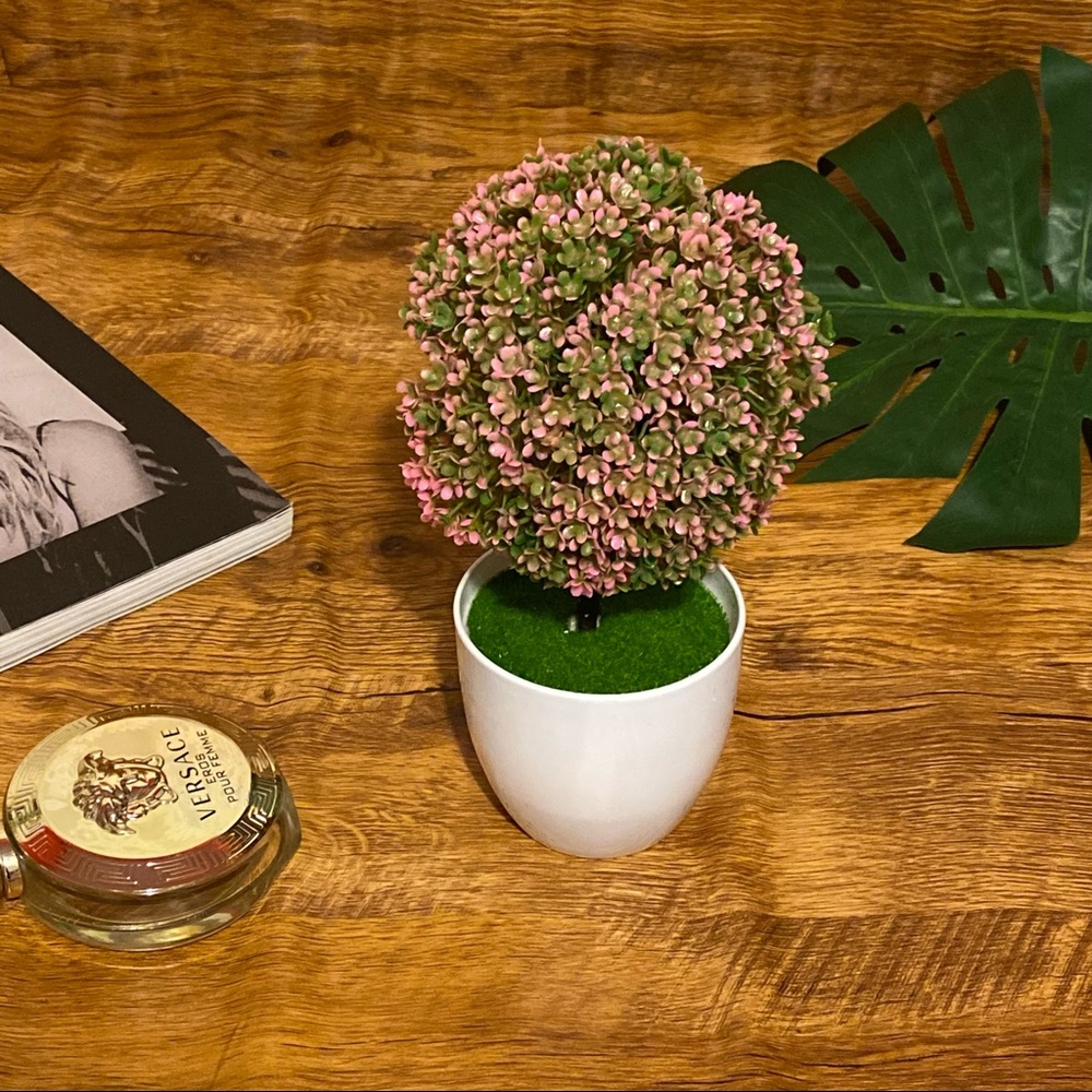 Artificial pink plant in white plastic pot decor